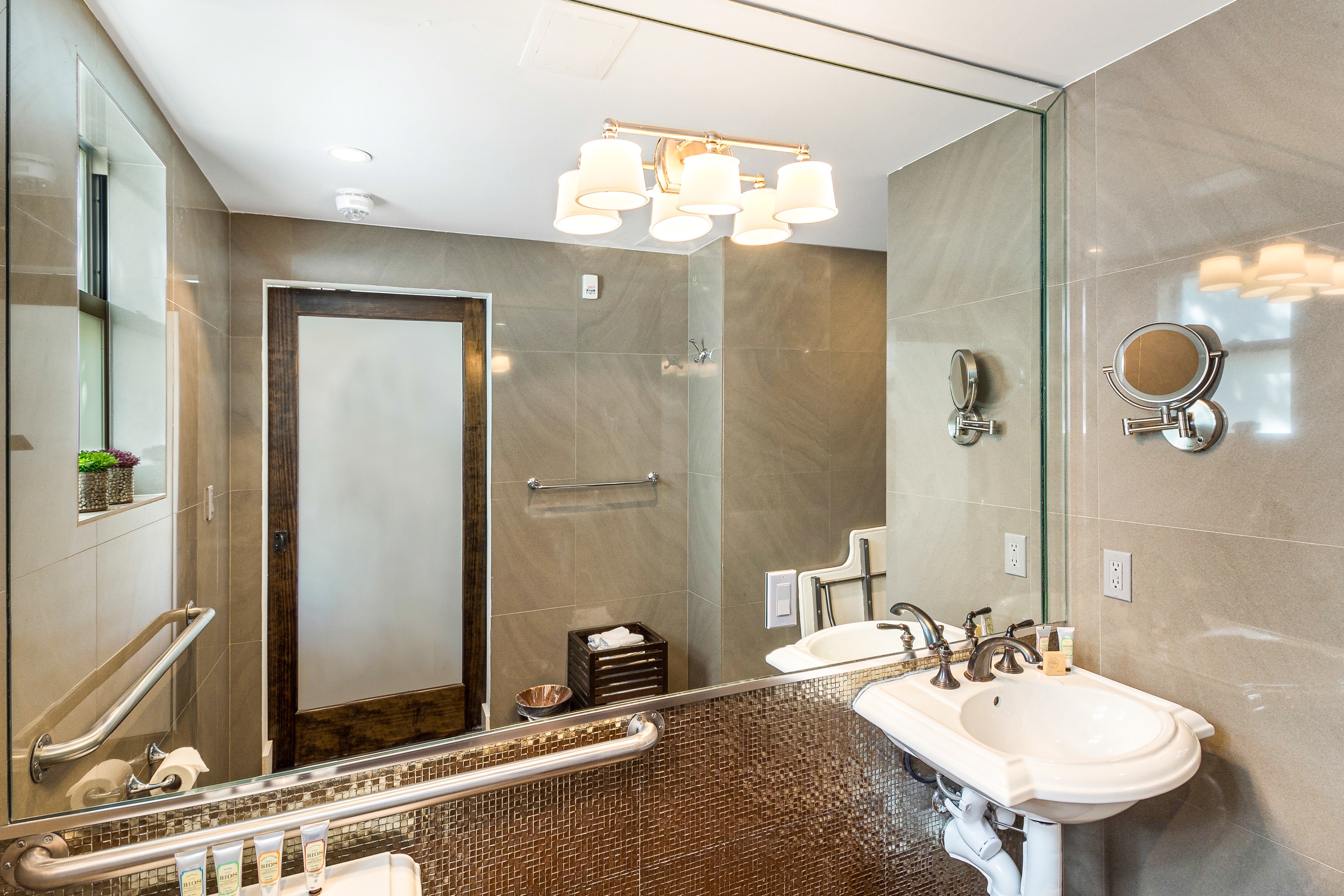 A bathroom with a shower, sink, and mirror