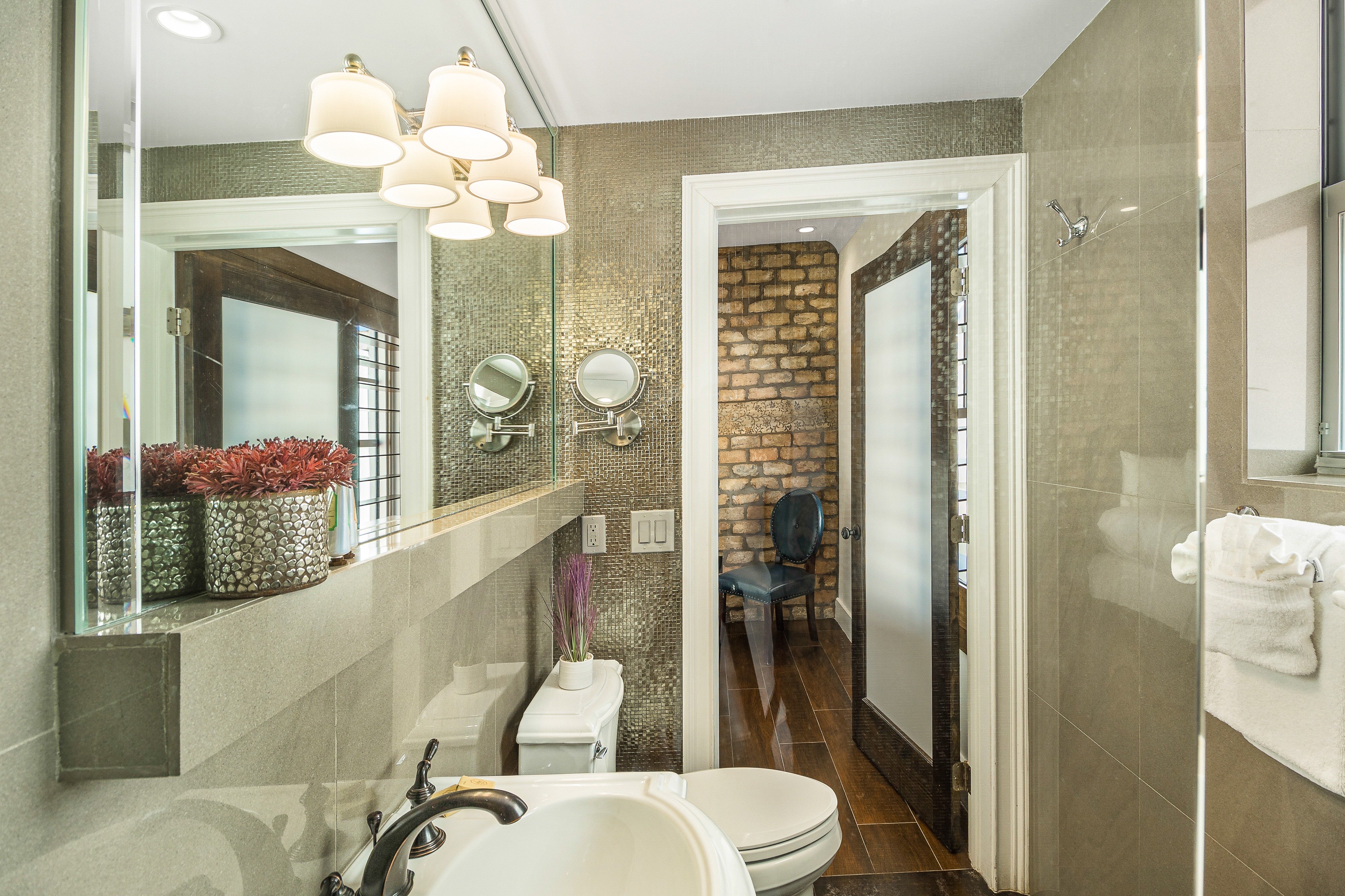 A modern bathroom with a toilet, sink, shower, and towels.